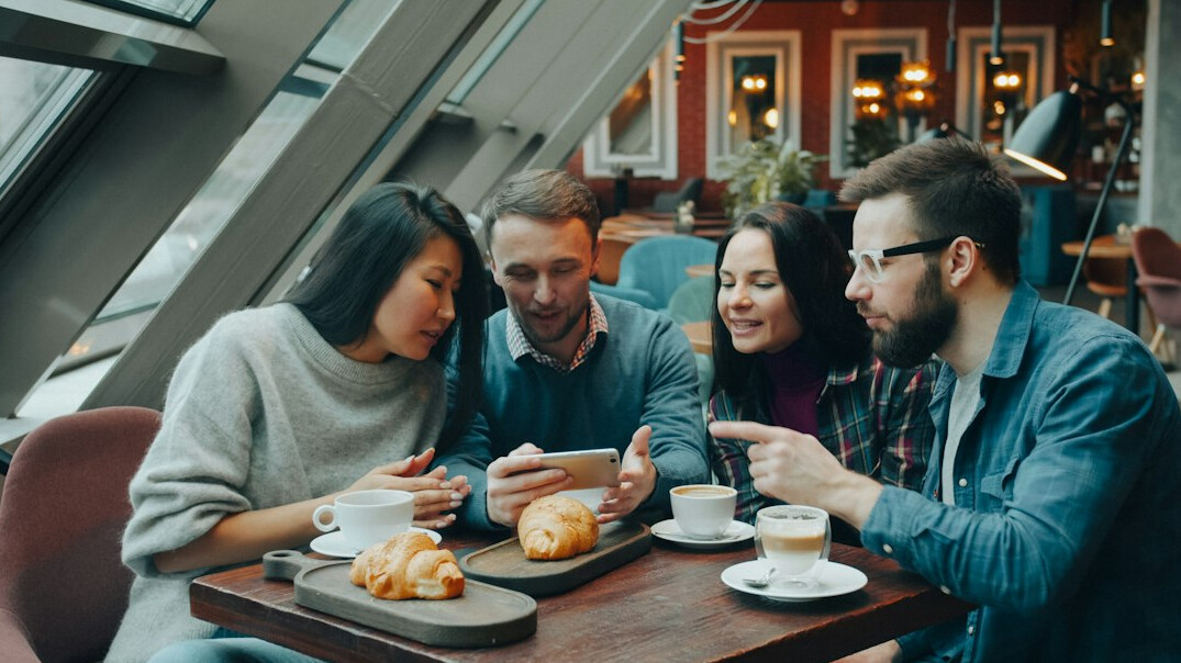 Diverse Portuguese editorial team discussing around a table
